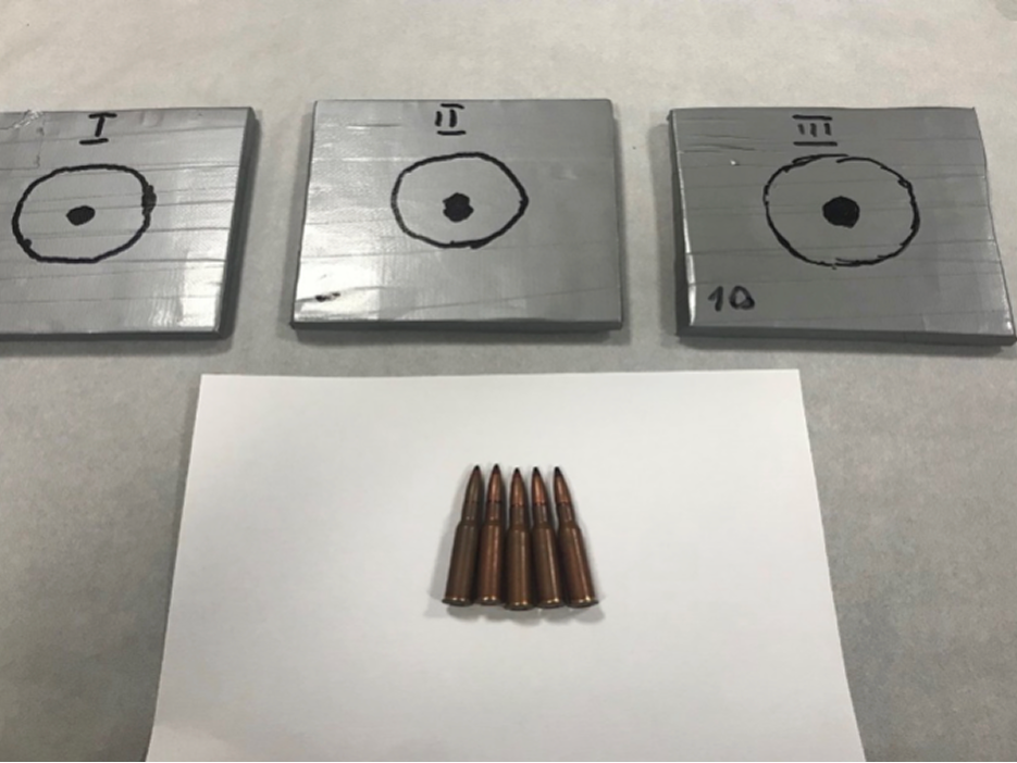 Tested armor panels with impact points alongside test cartridges